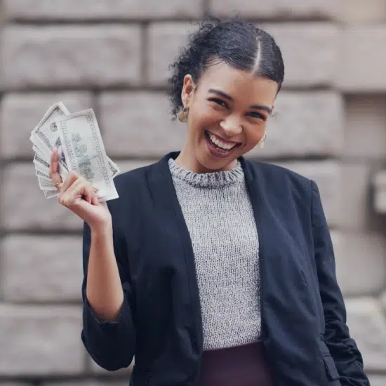 attractive young woman smiling while holding a stack of money in Milwaukee, Wi